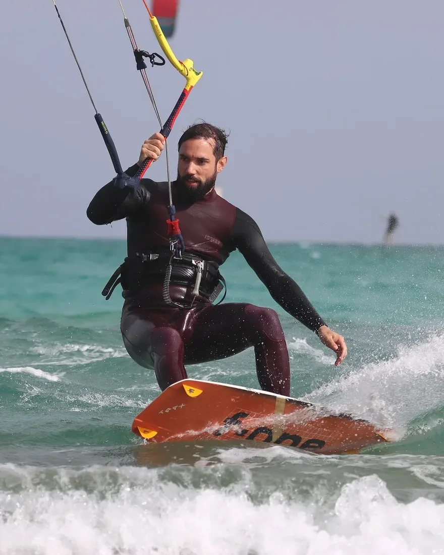 Antonin kitesurfing through turquoise water