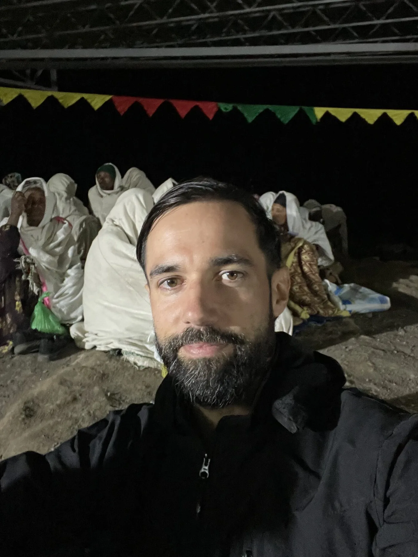 Antonin at the night vigil, with worshippers resting behind him